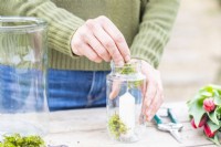 Woman placing moss around the base of the candle