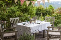 Terrace with set table and chairs, bunting decorated with lavender and other flowers - Lavender summer party story