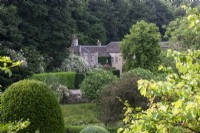 View across garden towards house at Moor Wood, Gloucestershire, with rambling roses.