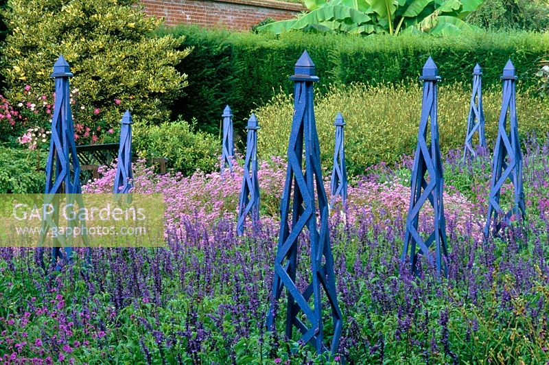 Wooden painted obelisks with Salvia and Verbenas at Wisley in Surrey RHS