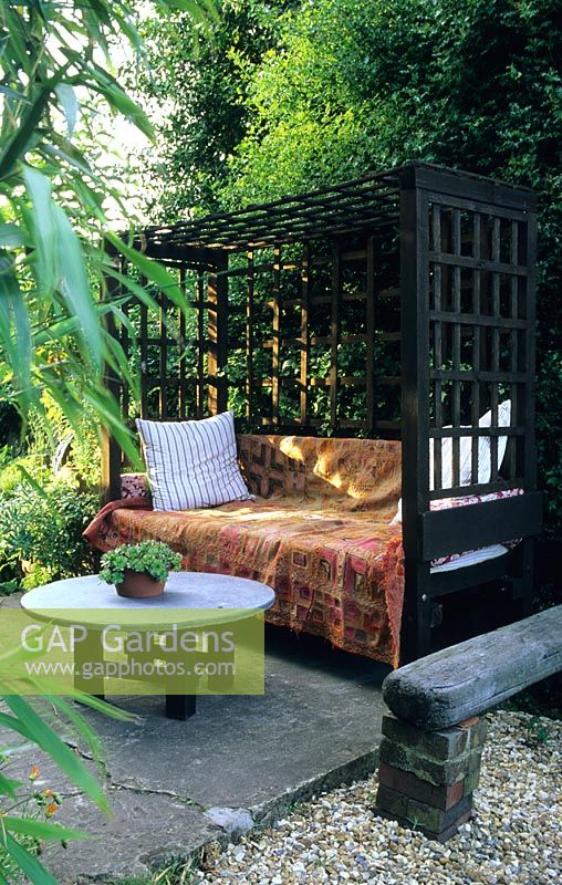 Secluded seating area in garden with covered bench