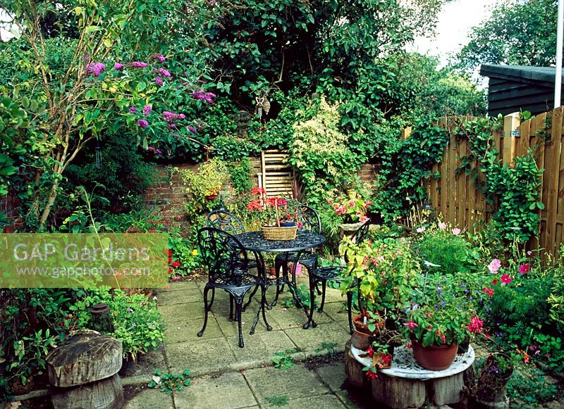 Small enclosed patio with metal table and chairs and pots - Grantham terrace