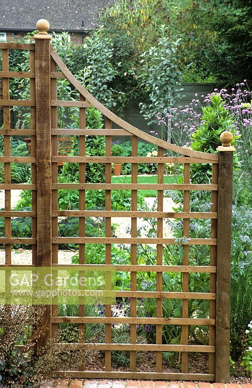 Square wooden trellis used as divider in a small garden