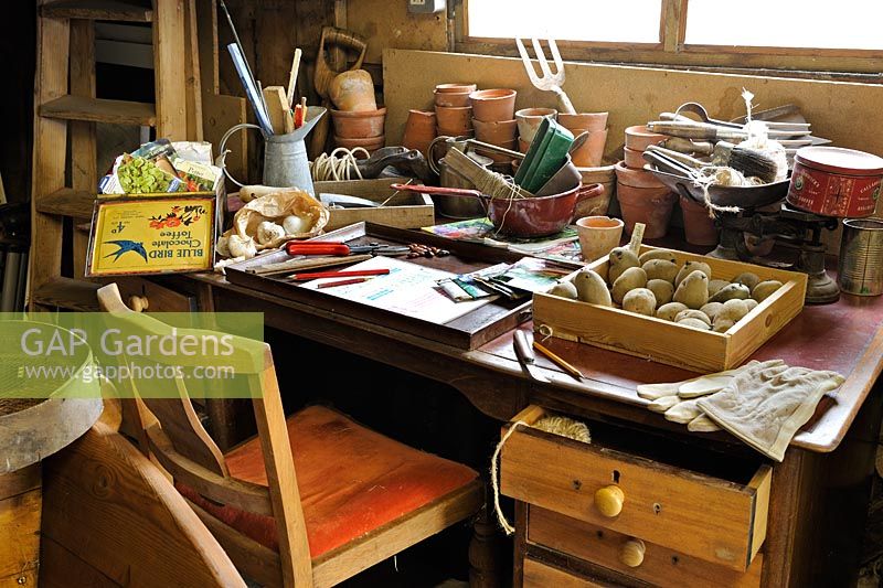 Gardeners desk in a large potting shed with seeds, seed potatoes, and gardening items, Norfolk, UK, March