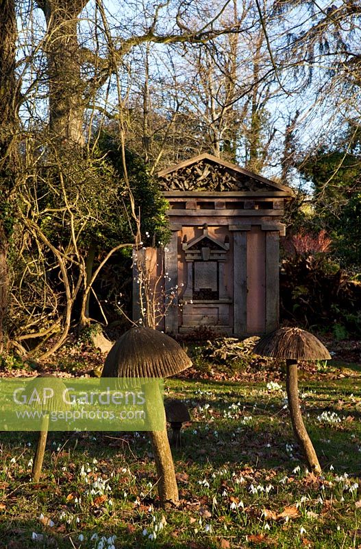 Wooden toadstool sculptures and one of the green oak temples, with Snowdrops in the Stumpery, Highgrove Garden, February 2011.