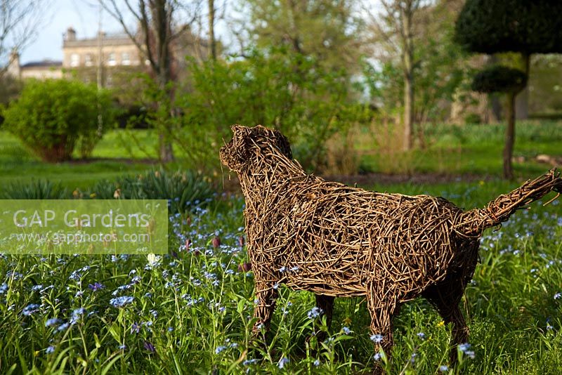 Dog sculpture and spring flowers in the Stumpery, Highgrove Garden, April 2010.