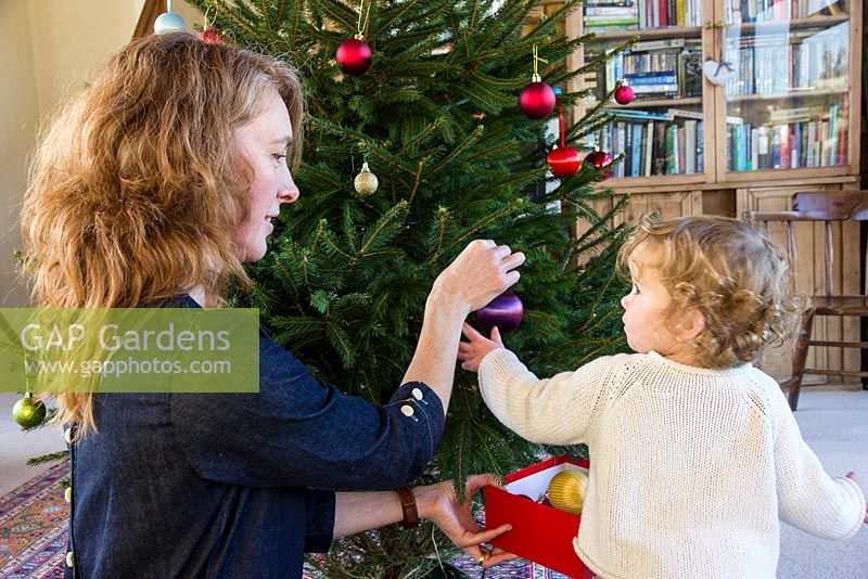Lady and child decorating a Christmas Tree