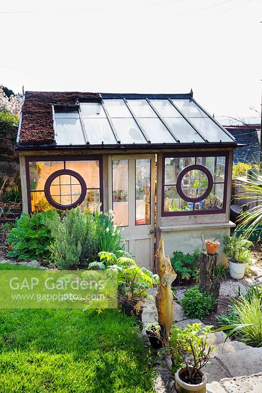 Lean to greenhouse made from architectural salvage building materials by Toby Buckland