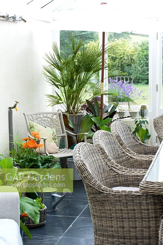 Conservatory with metal chair, wicker chairs and table and various containers