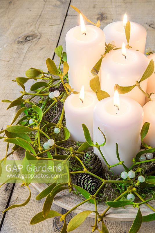 Candles decorated with Mistletoe, Pine cones and Alder.
