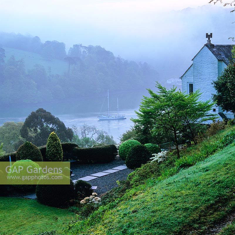 View of the cottage and Japanese-style terrace overlooking the River Dart on a misty morning.