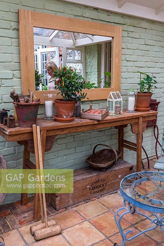 A conservatory with a selection of vintage gardening tools and paraphernalia.