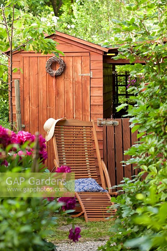 Relaxing beach area with seaside hut style shed. Paeonia lactiflora 'Bunker Hill'