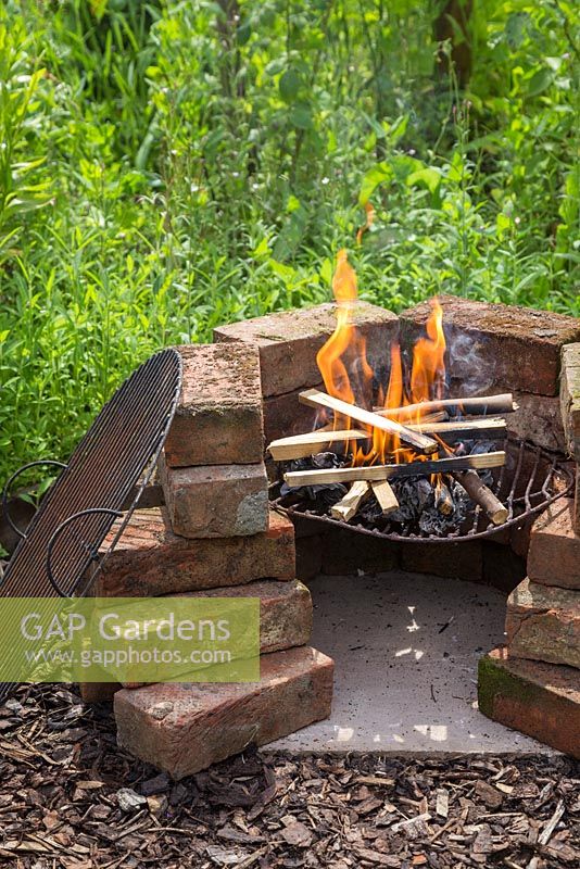 A homemade barbecue with a fire on the go
