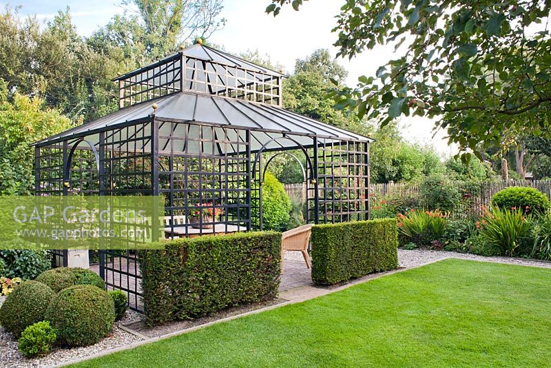Pavillon in formal garden with clipped Buxus and Yew in borders. Anneke Meinhardt garden