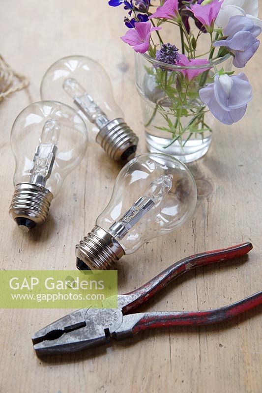 Making hanging flower vases from lightbulbs. Remove the small silver end cover with tweezers of pliers, this should just pull off.