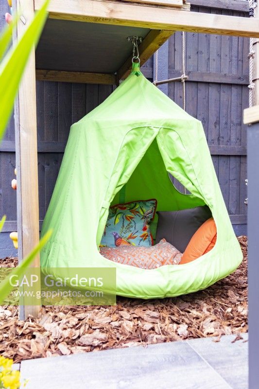 Hanging tent seat underneath children's climbing frame