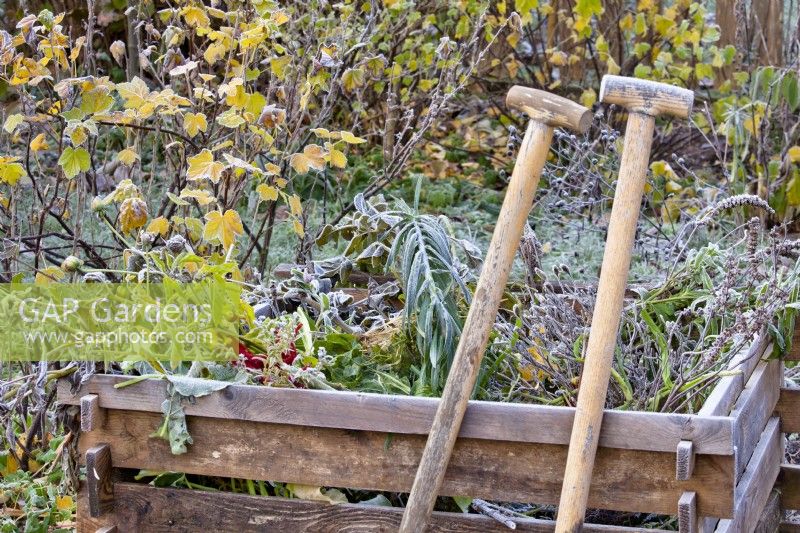 Compost heap and tools in winter frost.