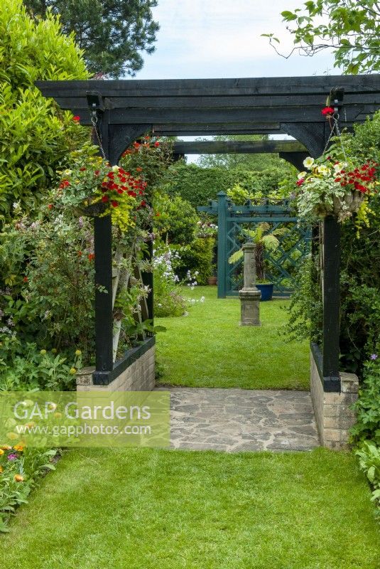 View through pergola with hanging baskets to armillary  - Open Gardens Day, East Bergholt, Suffolk