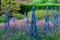 Wooden painted obelisks with Salvia and Verbenas at Wisley in Surrey RHS