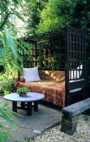 Secluded seating area in garden with covered bench