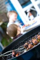 Barbecue with children in the background