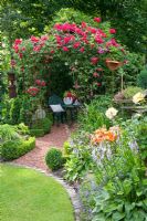 Seating area under pavillon with climbing rose