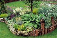 Stone and log edging to island bed planted with Hosta, Allium and Astilbe