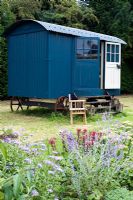 Shephard's hut with seating and lanterns in late summer - Woodpeckers Essex NGS