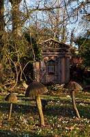 Wooden toadstool sculptures and one of the green oak temples, with Snowdrops in the Stumpery, Highgrove Garden, February 2011.