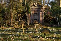 Wooden toadstool sculpture and green oak temple with snow drops in the Stumpery, February 2011.
