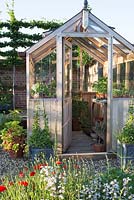 Wooden greenhouse in potager in summer