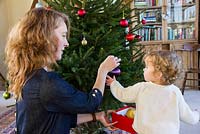 Lady and child decorating a Christmas Tree