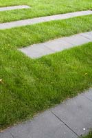Lawn with stepping stone slabs.