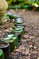 Bottles used as path edging feature in an urban garden