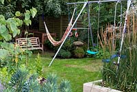 A swing and hammock in the children's play area hidden at the bottom of the garden.