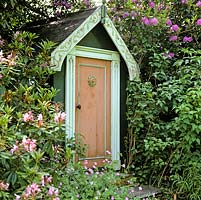 Tucked away in shade of rhododendron, a childrens playhouse.