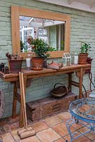 A conservatory with a selection of vintage gardening tools and paraphernalia.