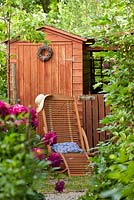 Relaxing beach area with seaside hut style shed. Paeonia lactiflora 'Bunker Hill'