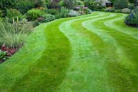Lawn with mown pattern between summer borders 