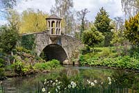 The Watch Tower and stone bridge over the Water Garden, edged by Gunnera and Iris.