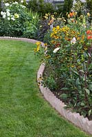Sawtooth style brick edging containing a border of mixed Dahlias and Heleniums
