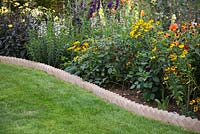Sawtooth style brick edging containing a border of mixed Dahlias, Penstemon and Heleniums