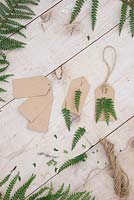 Paper gift tags with green Fern foliage inserted into them