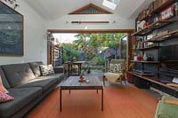 Wide view of living room in home belonging to Fiona Jopp, with view to  small courtyard garden