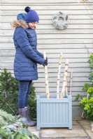Woman placing birch branches in the container