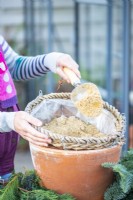 Woman adding sand to the hanging basket