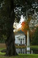 Brilliant orange autumn foliage and a reflecting pool next to the Ionic Temple and Obelisk at Chiswick House and Garden.