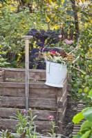 Bucket with garden waste on compost bin.