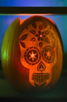 Halloween carved and decorated pumpkin lantern depicting a skull.  October